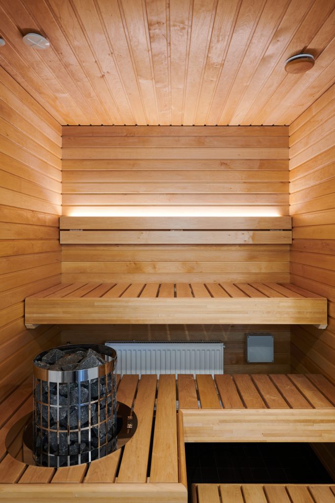Saunassa tilaa on säästetty lasiseinällä. Kiuas upotettiin lauteeseen ja selkänojassa on valolista.